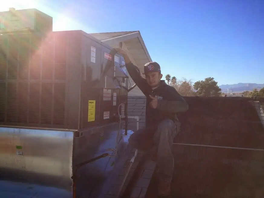 HVAC technician performing Heat Pump Repair on a rooftop unit in Bryant